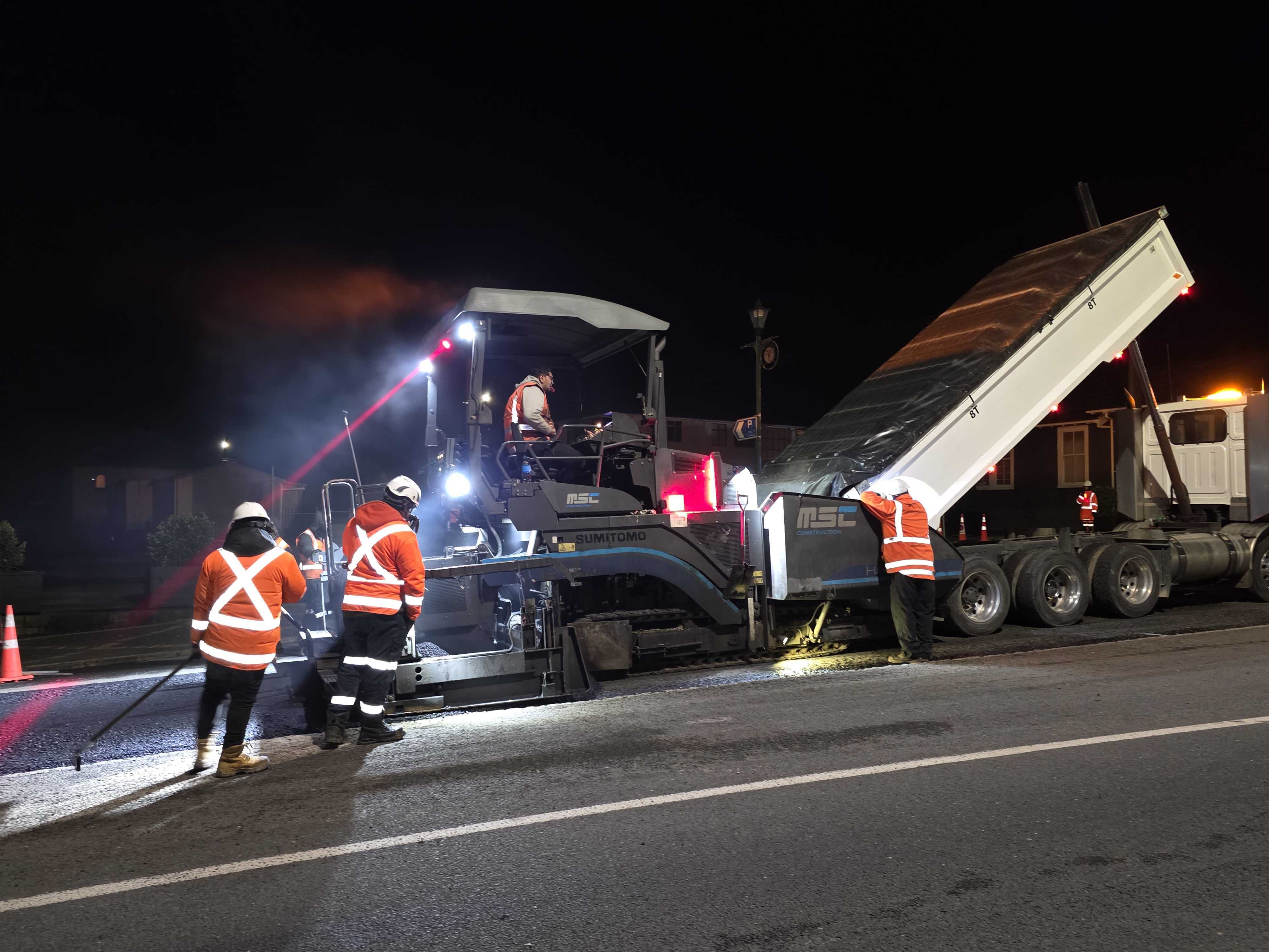 MS Civil crew paving at night, a tipper feeding the paver